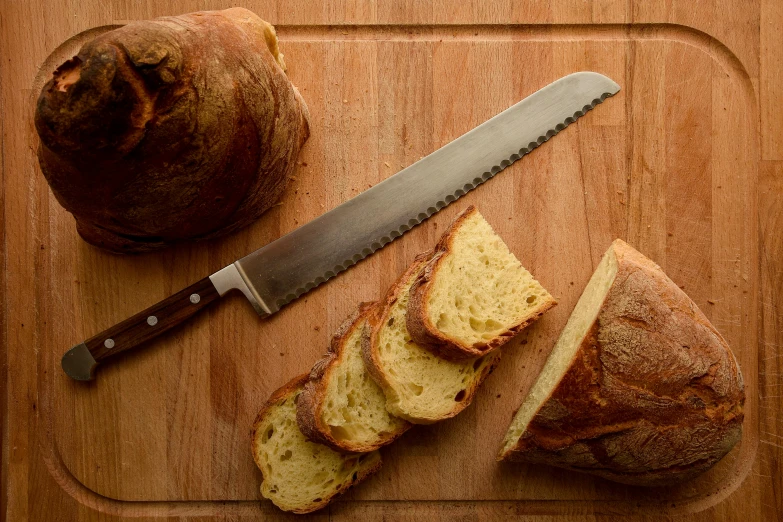 a loaf of bread and a knife on a cutting board, inspired by Richmond Barthé, unsplash, renaissance, slide show, panini, award - winning crisp details ”, with a soft