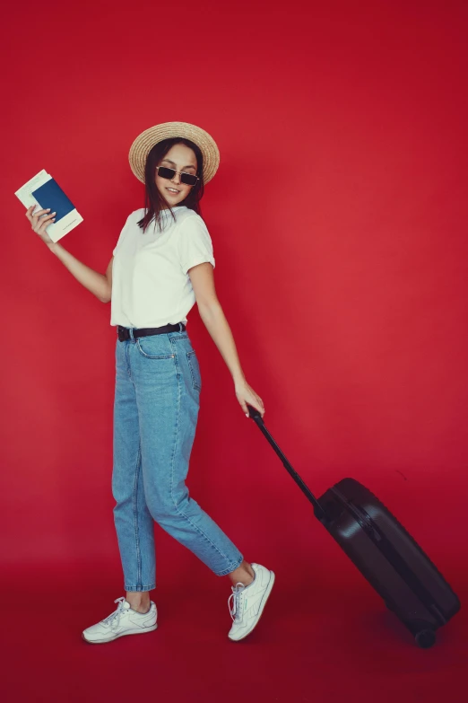 a woman walking with a suitcase and a passport, pexels contest winner, minimalism, in red background, white shirt and jeans, woman with hat, roaming entertainers