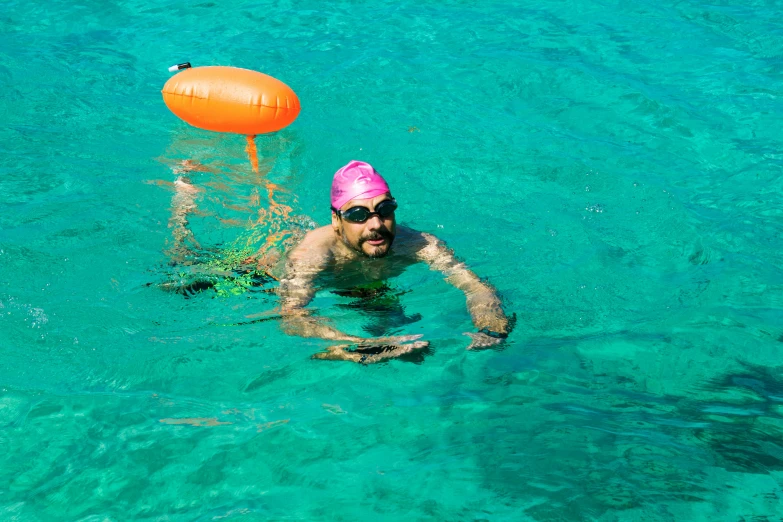 a man that is in the water with a frisbee, with neon visor, philippe starck, carribean turquoise water, h3h3