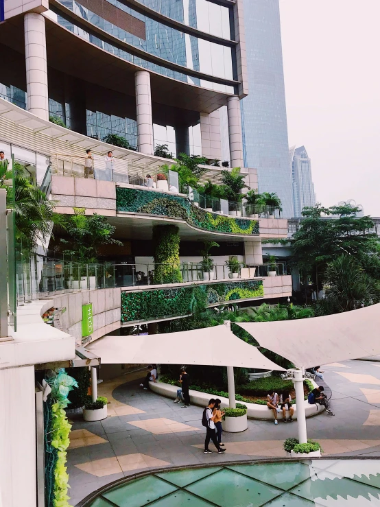 a group of people standing in front of a building, the city is full of green plants, bangkok townsquare, 💋 💄 👠 👗, as seen from the canopy