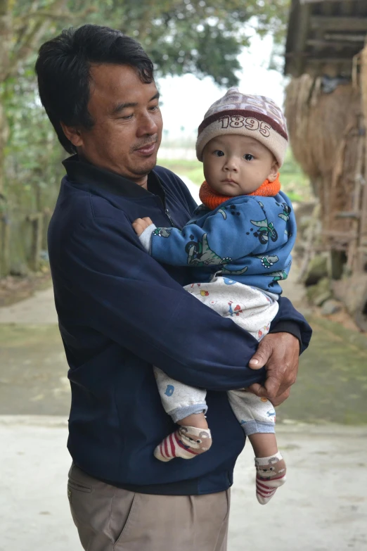 a man holding a baby in his arms, inspired by Huang Guangjian, sumatraism, slide show, toddler, no crop