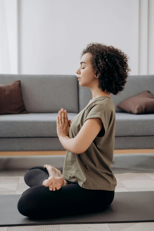 a woman sitting on a yoga mat in a living room, pexels contest winner, renaissance, praying posture, square, dynamic moving pose, plain background