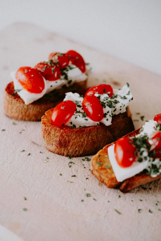 three pieces of bread topped with cheese and tomatoes, by Tom Bonson, unsplash, cream of the crop, basil, crispy, caparisons