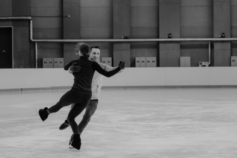 a man riding a skateboard on top of an ice rink, a black and white photo, by Emma Andijewska, pexels contest winner, couple dancing, animation, indoor, smiling and dancing