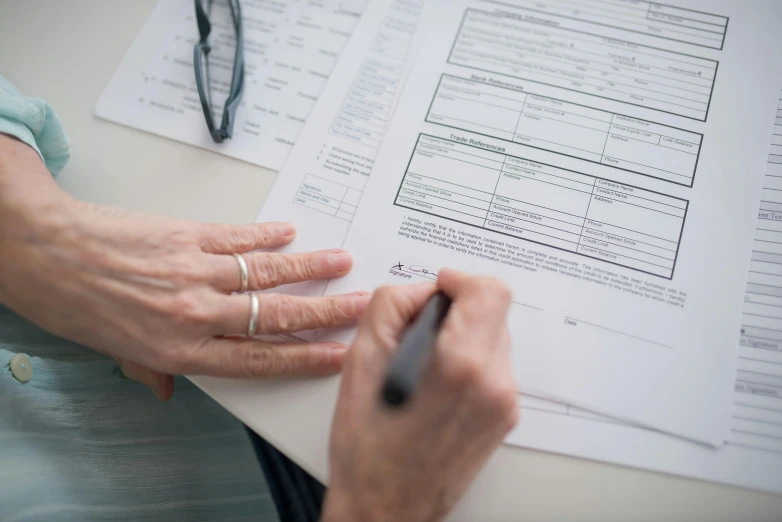 a person sitting at a table with papers and a pen, selling insurance, 15081959 21121991 01012000 4k, high-quality photo, eye - level view