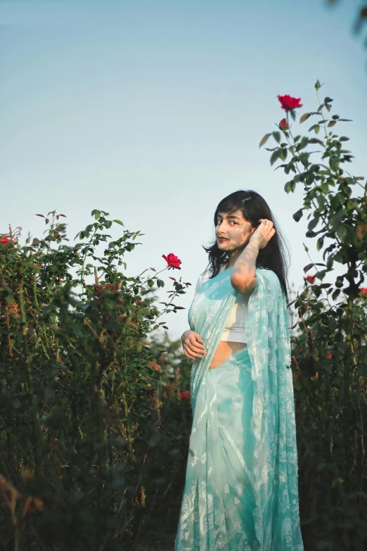 a woman in a blue sari standing in a garden, an album cover, inspired by Elsa Bleda, pexels contest winner, roses, cloudless sky, young asian woman, 15081959 21121991 01012000 4k