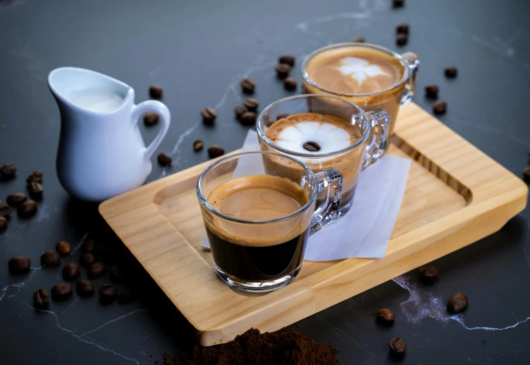three cups of coffee sitting on top of a wooden tray, by Julia Pishtar, small square glasses, three michelin star, thumbnail, filling the frame