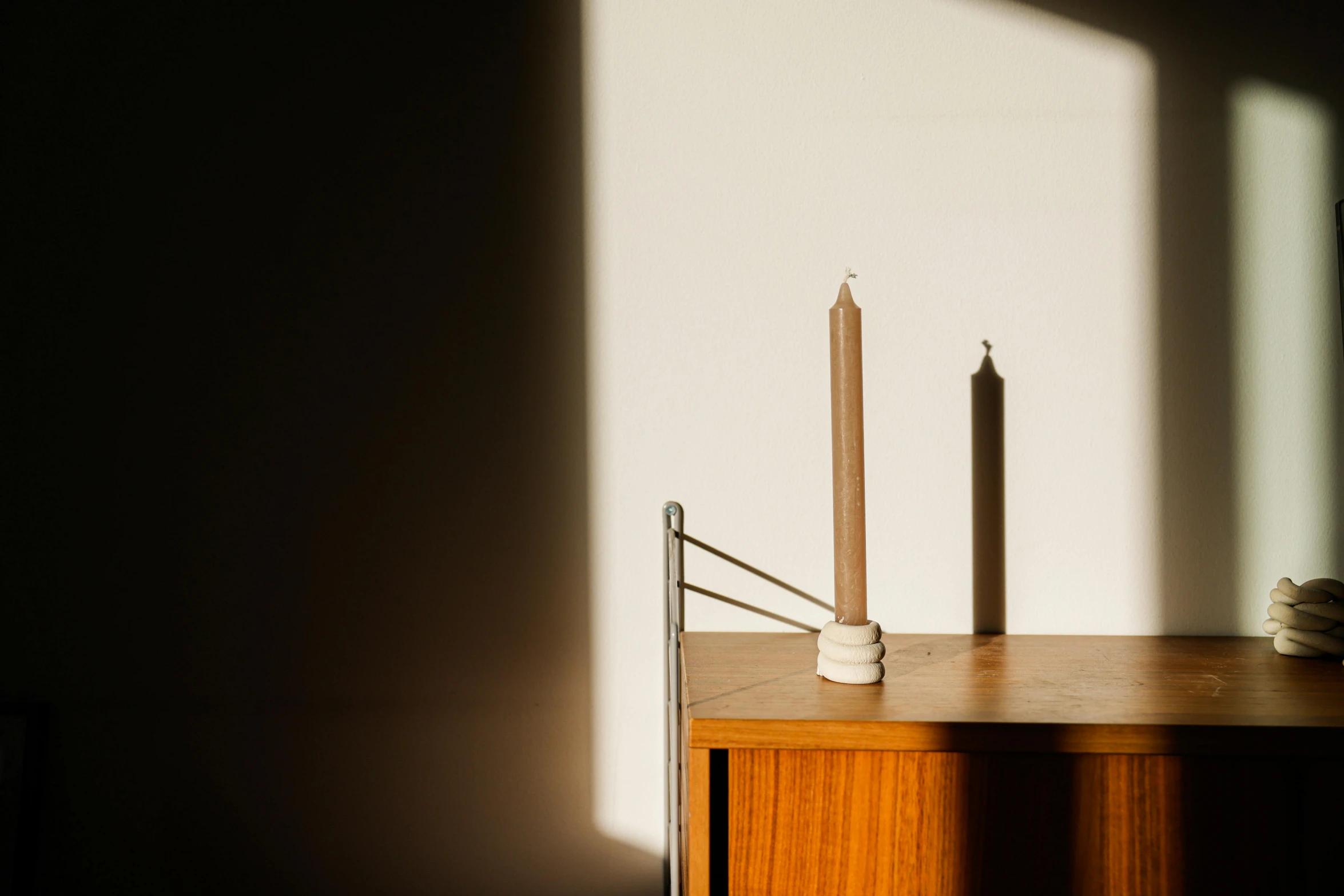 a couple of candles sitting on top of a wooden table, an abstract sculpture, inspired by Giorgio Morandi, unsplash, minimalism, sun lit, ad image, alvar aalto, detailed product image