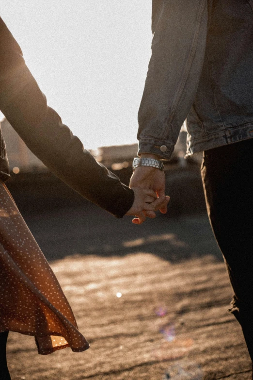 a close up of two people holding hands, a picture, trending on pexels, lightly dressed, low sun, attractive girl, paul barson