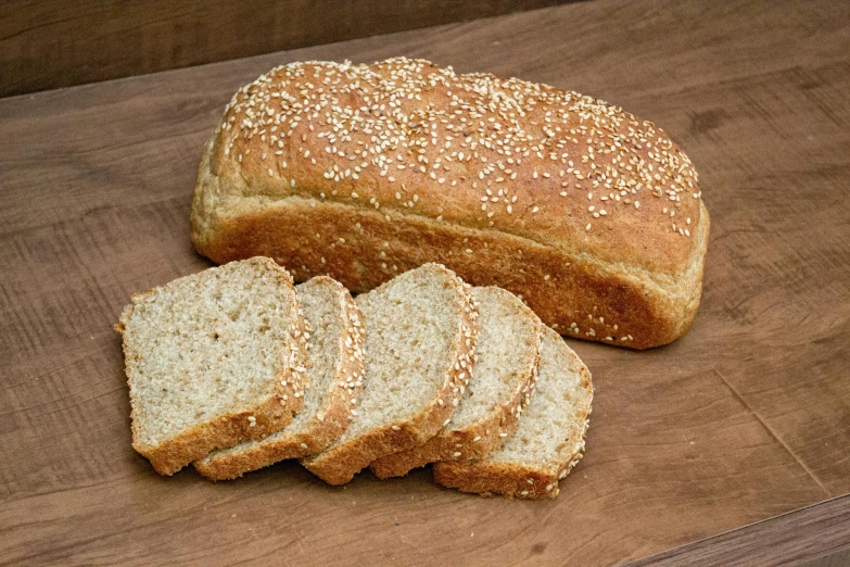 a loaf of bread sitting on top of a wooden cutting board, luscious with sesame seeds, various sizes, sandstone, full-size