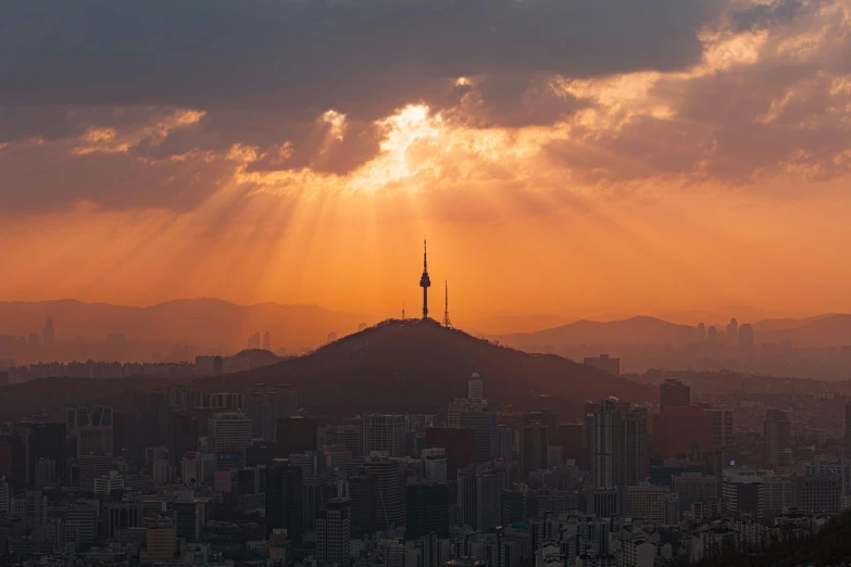 the sun shines through the clouds over a city, a picture, by Jang Seung-eop, pexels contest winner, korean, warm light, skyline, fan favorite