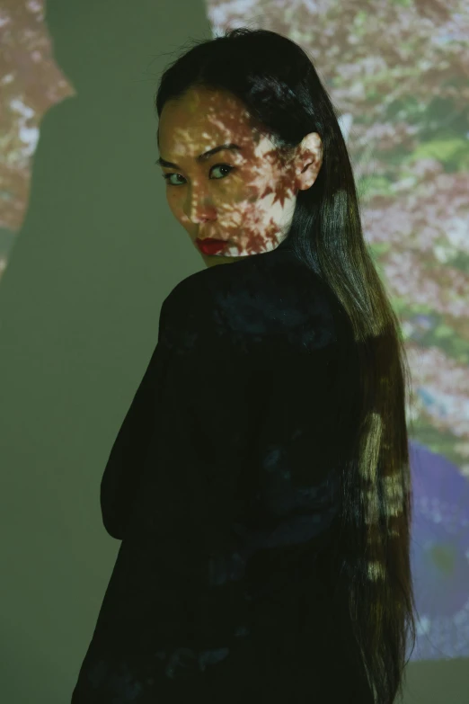 a woman standing in front of a projection, inspired by Ren Hang, portrait of ariana grande, long black hair in a ponytail, ivy, ((portrait))