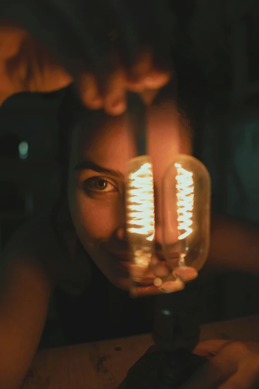 a woman holding a light bulb in front of her face, pexels contest winner, renaissance, glowing tubes, close-up portrait film still, electronics see through, slightly tanned