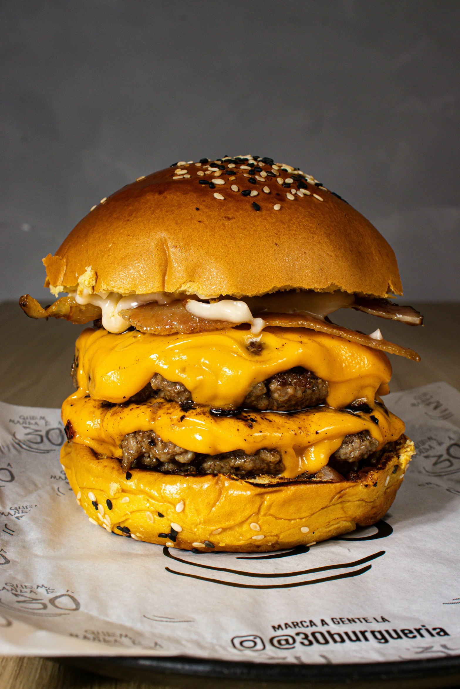 a cheeseburger sitting on top of a piece of paper, inspired by Joris van der Haagen, unsplash, hyperrealism, extremely detailed frontal angle, melted cheddar, big macs, split in half