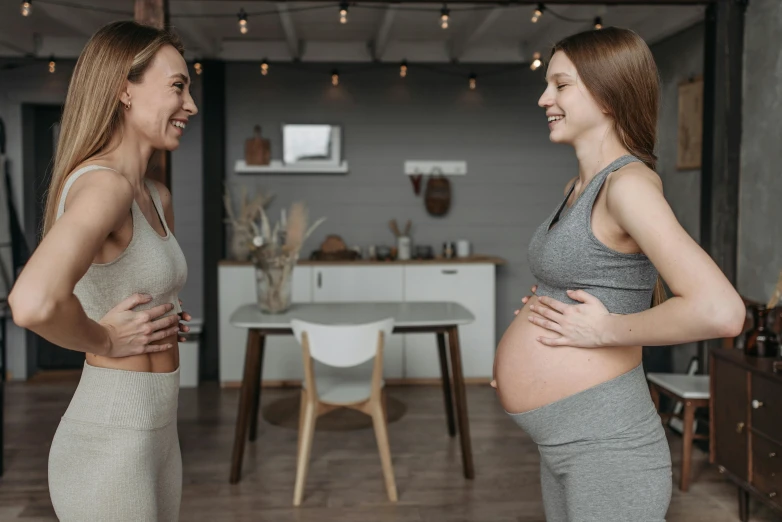 a couple of women standing next to each other, happening, pregnancy, avatar image, laughing, indoor picture