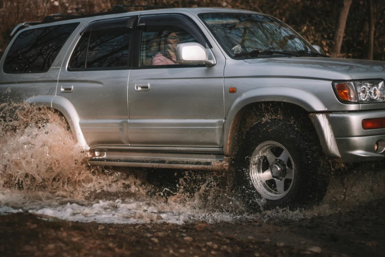 a silver suv driving through a puddle of water, pexels contest winner, profile photo, 90s photo, hunting, action sports