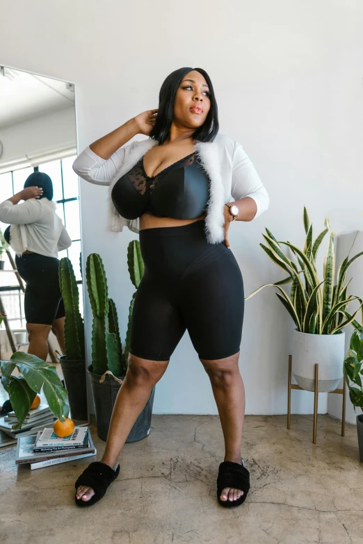 a woman standing in front of a mirror in a room, tight black tank top and shorts, large hips, sharp focus », wearing tight suit