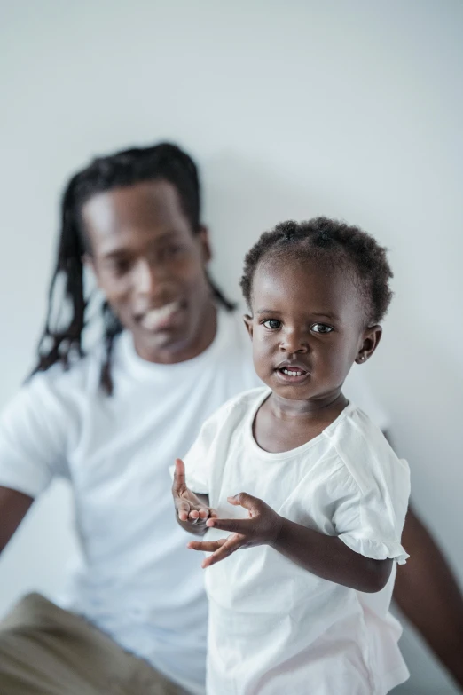 a man and a little girl sitting on a bed, pexels contest winner, black arts movement, afro comb, proud serious expression, toddler, ( ( dark skin ) )