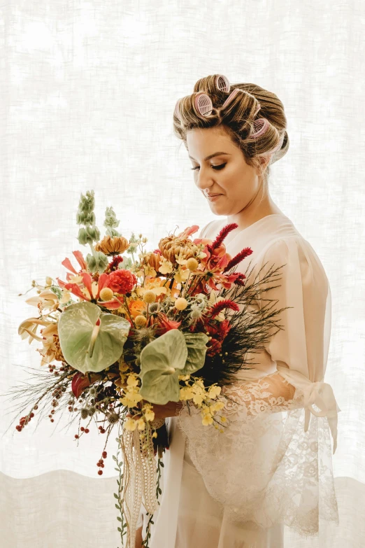 a woman holding a large bouquet of flowers, a photo, inspired by Rudolf von Alt, unsplash, art nouveau, bride, zoomed out view, fall, elaborate hair worn up