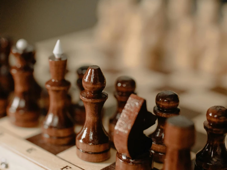 a group of wooden chess pieces sitting on top of a chess board, by Emma Andijewska, trending on unsplash, fan favorite, brown, close - up profile, thumbnail