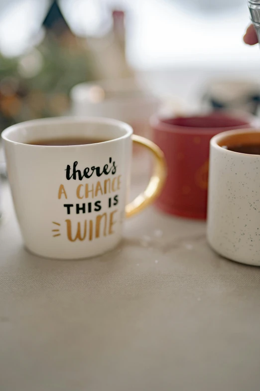 a close up of two coffee mugs on a table, pexels contest winner, happening, themed after wine, saying, profile image, various items