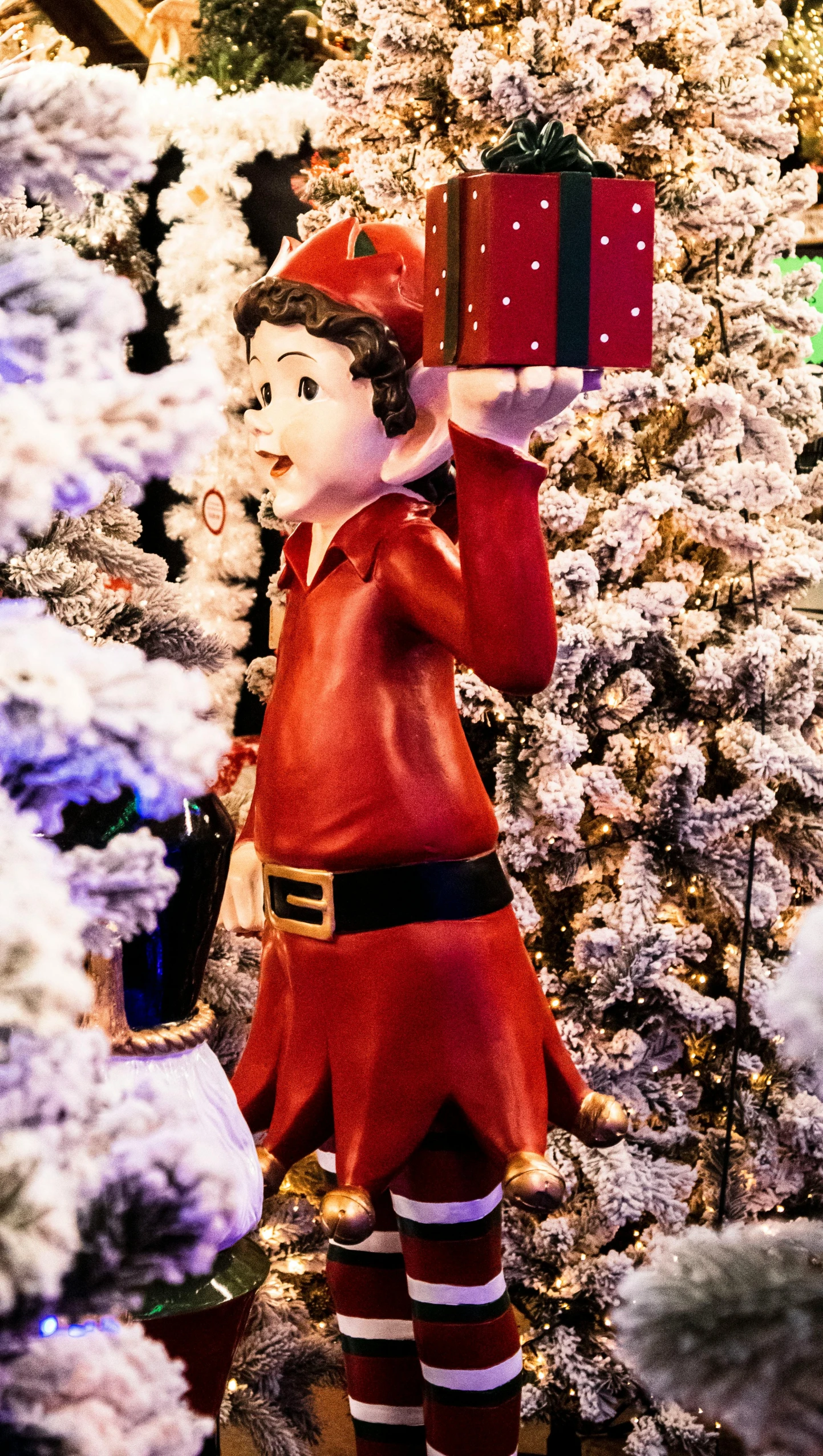 a statue of a santa claus in front of a christmas tree, by disney, pexels, a portrait of a male elf, walking down, betty boop, detail shot