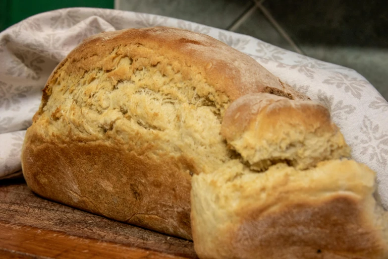 a loaf of bread sitting on top of a wooden cutting board, golden eal, irish, pochi iida, no cropping