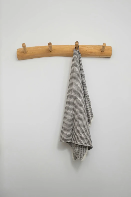 a towel hanging on a hook on a wall, by David Simpson, minimalism, wooden staff, oak, loosely cross hatched, solid grey