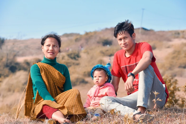 a couple of people that are sitting in the grass, a portrait, pexels contest winner, young himalayan woman, husband wife and son, avatar image, roadside