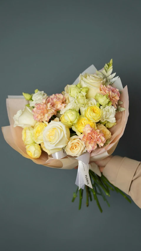 a person holding a bunch of flowers in their hand, a pastel, inspired by François Boquet, unsplash, light yellow, on a gray background, glossy surface, sweet hugs