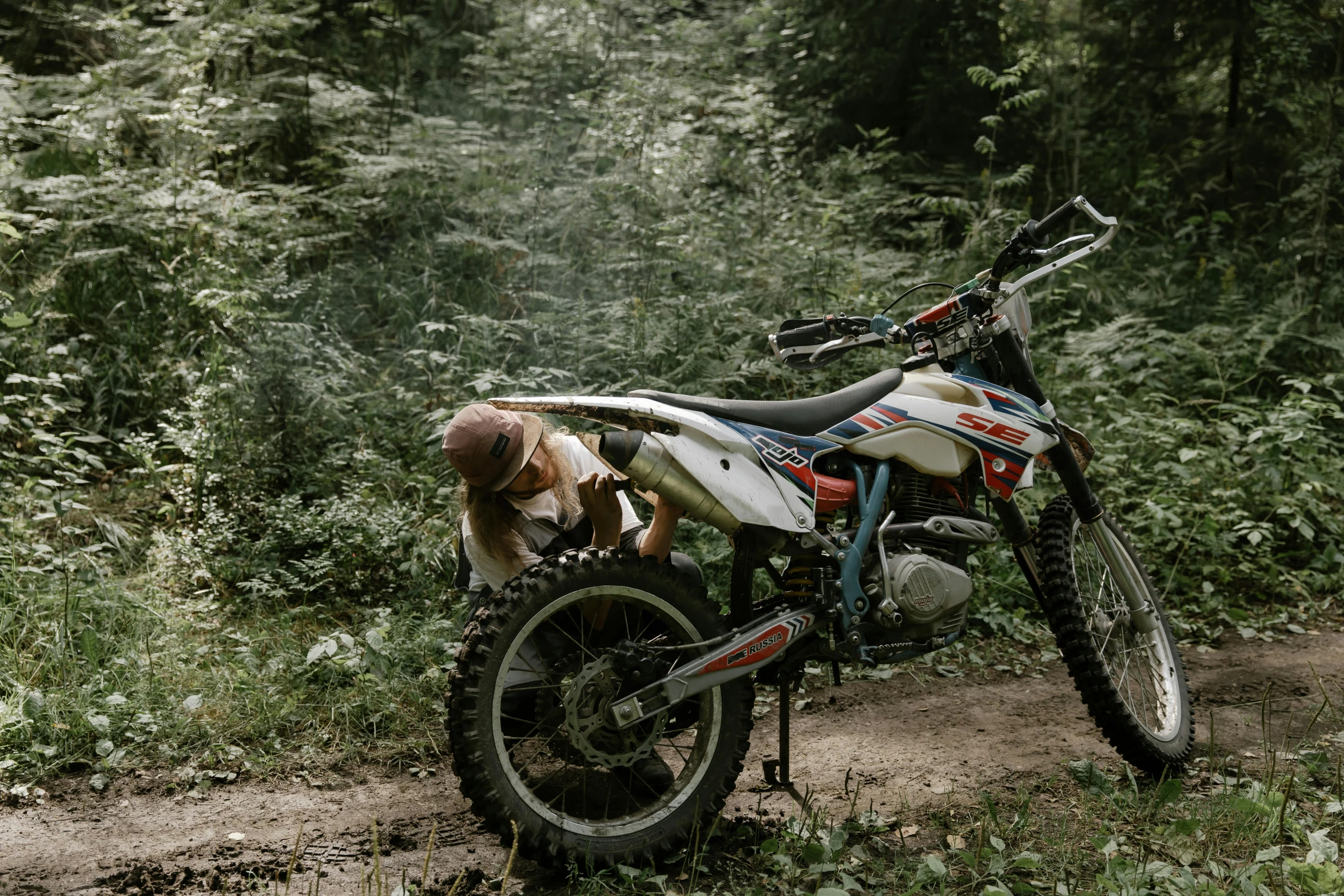 a dirt bike parked on the side of a dirt road, by Emma Andijewska, pexels contest winner, figuration libre, sitting in the forrest, avatar image, crawling, upset