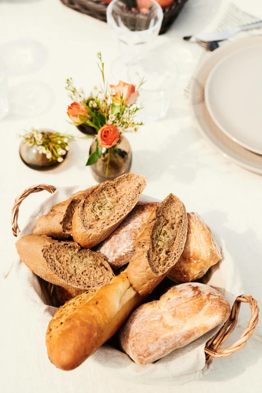 a plate of bread and breadsticks on a table, bouquet, holding a baguette, award - winning details, epicurious