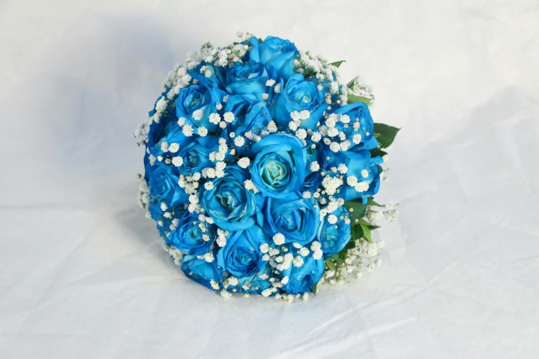 a bridal bouquet of blue roses and baby's breath, fully decorated, azure sky tones, vibrant colour, 3/4 front view