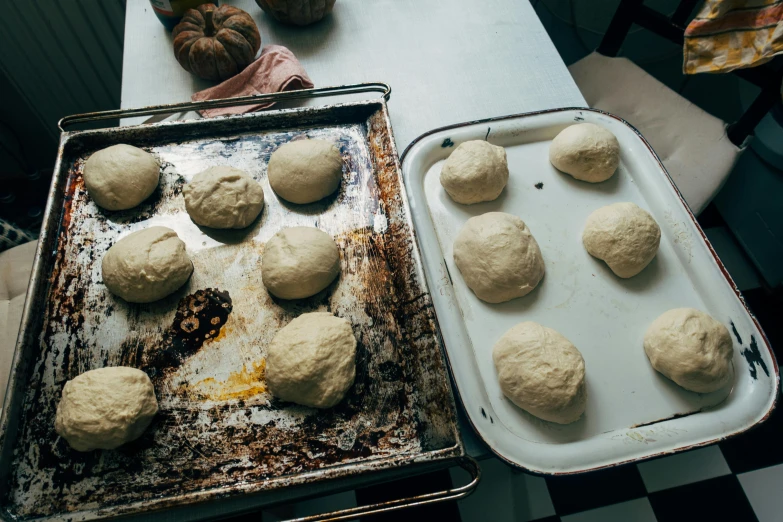 a couple of trays of dough sitting on top of a table, by Julia Pishtar, cooking, multiple stories, thumbnail, loaves