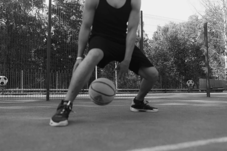 a man dribbling a basketball on a court, a black and white photo, figuration libre, squatting, homemade, lowres, gif