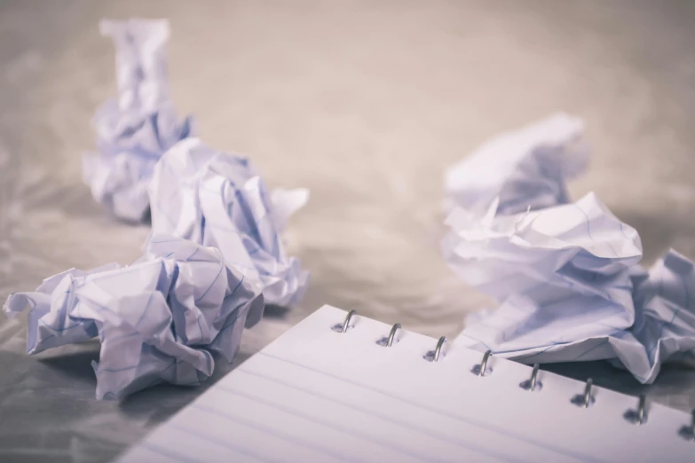 a pile of crumpled paper next to a notepad, pexels, 15081959 21121991 01012000 4k, empty and uncany expression, childish, writing a letter