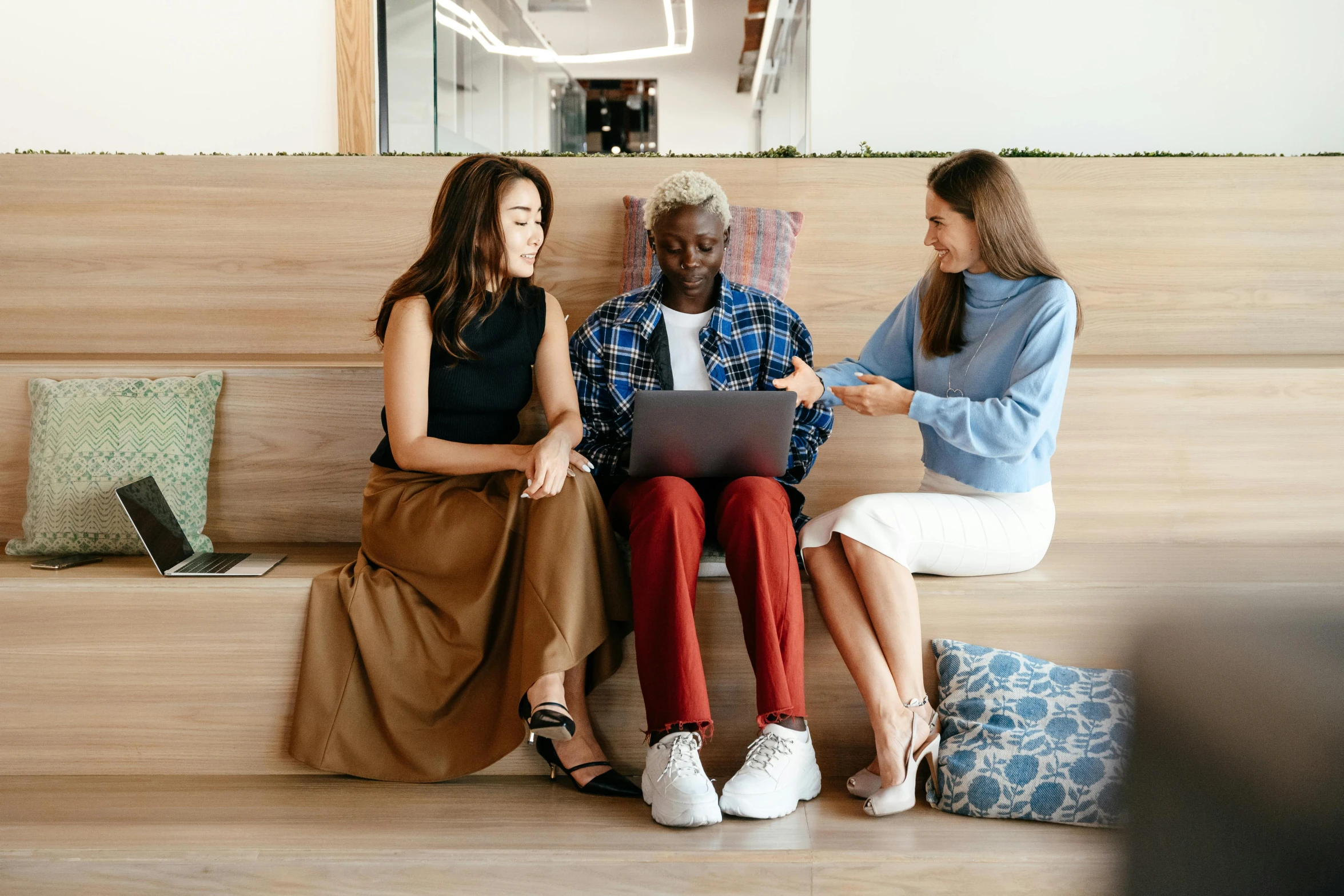 three women sitting on a bench looking at a laptop, trending on pexels, two buddies sitting in a room, avatar image, diverse outfits, professional image