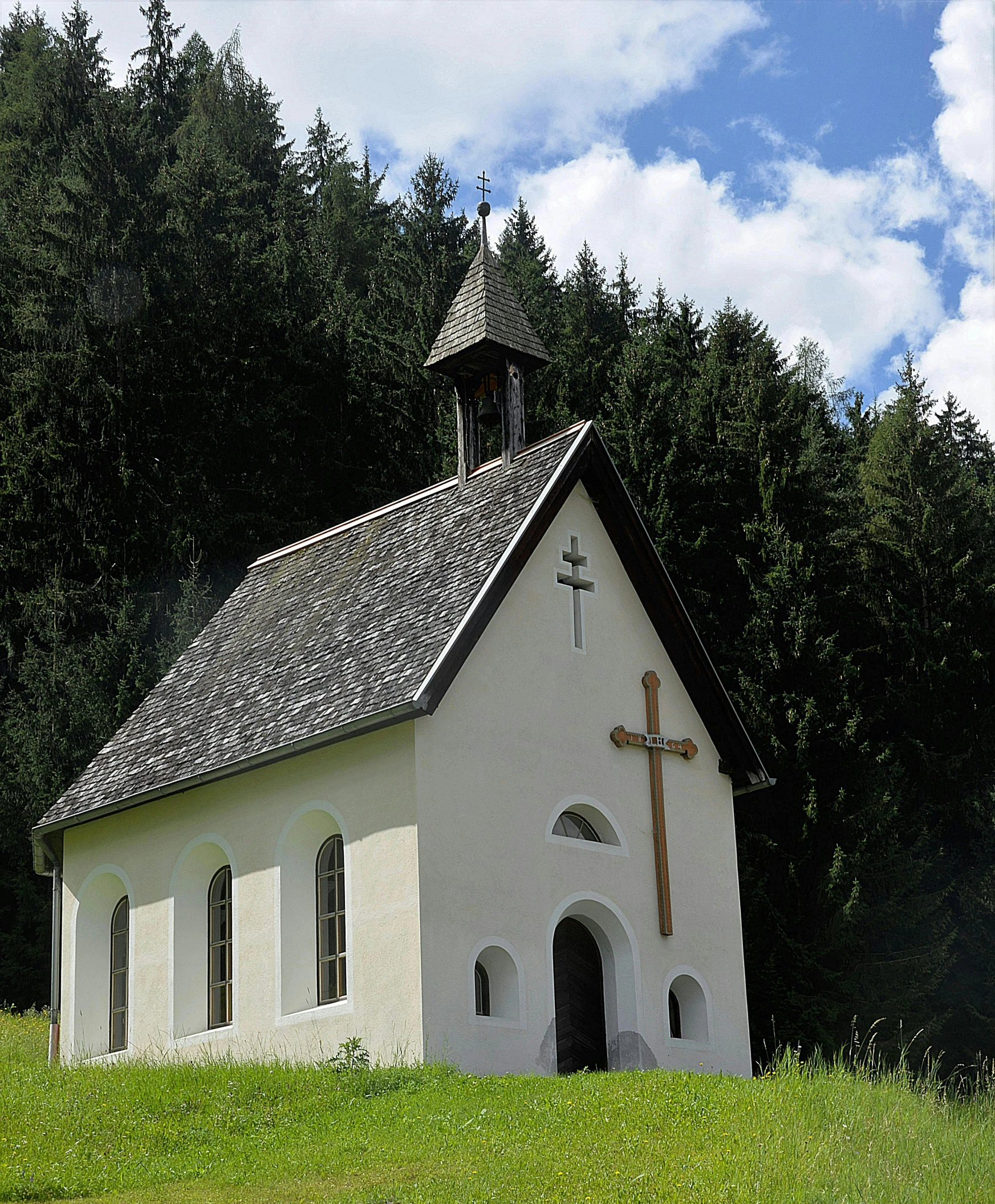 a small white church sitting on top of a lush green hillside, an album cover, by Matthias Stom, pexels, renaissance, square, chalet, no cropping, front facing