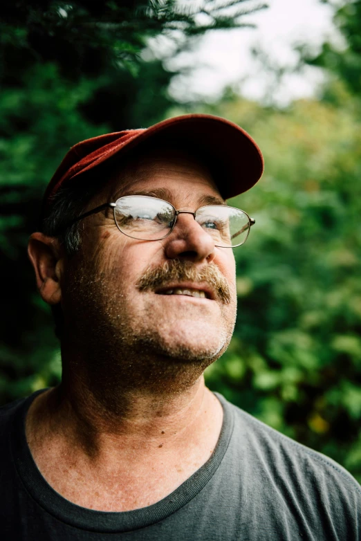 a close up of a person wearing a hat and glasses, by Steve Brodner, lush surroundings, smiling man, dan ouellette, profile image