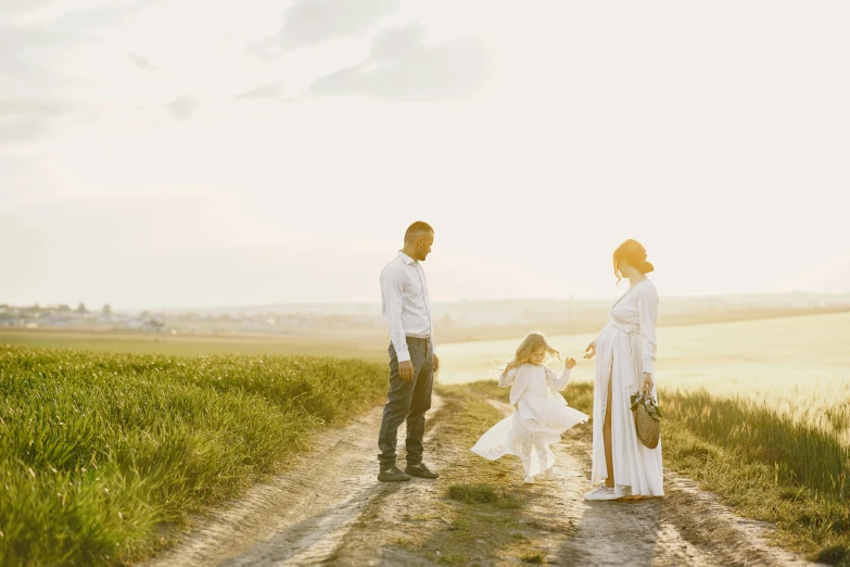 a man and woman walking down a dirt road, pexels contest winner, renaissance, portrait of family of three, wearing a white dress, evening sun, families playing