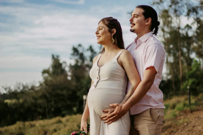 a man and a woman standing next to each other, a picture, pexels contest winner, happening, maternity feeling, te pae, hispanic, hills in the background