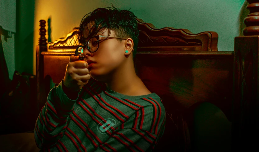 a woman sitting on a bed smoking a cigarette, inspired by Elsa Bleda, trending on pexels, thick glasses, people with mohawks, asian male, holding a small vape