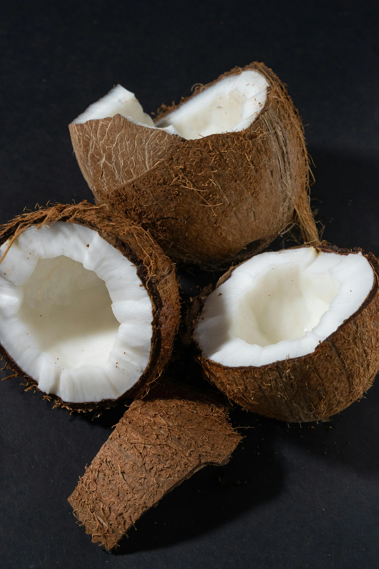 a group of coconuts sitting on top of a table, on a black background, detailed product image, slide show, panel