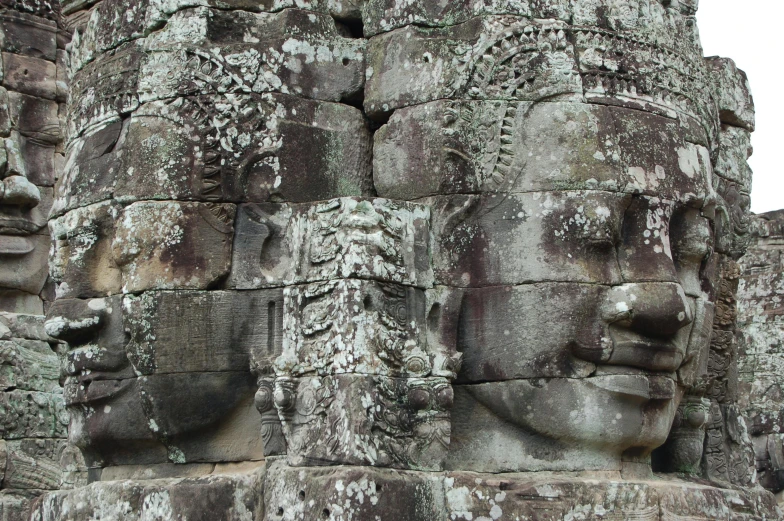 a close up of a face on the side of a building, large temples, twins, stone face, full face frontal centred