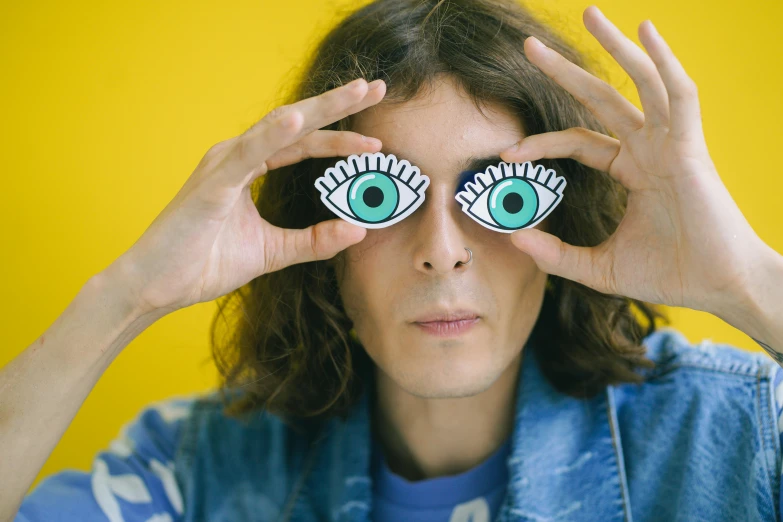 a woman covering her eyes with her hands, an album cover, adam ondra, circular glasses, one yellow and one blue eye, looking away from camera