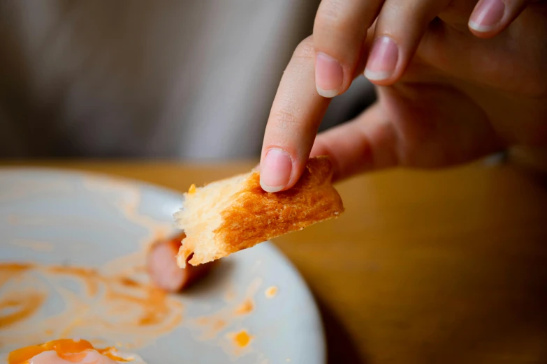 a person taking a piece of food out of a plate, eating garlic bread, scratched, no text, extra crisp image