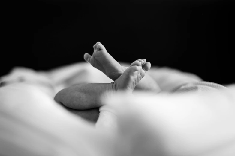 a black and white photo of a baby's feet, a black and white photo, by Emma Andijewska, pexels, nursing, crossed arms, animation, touch