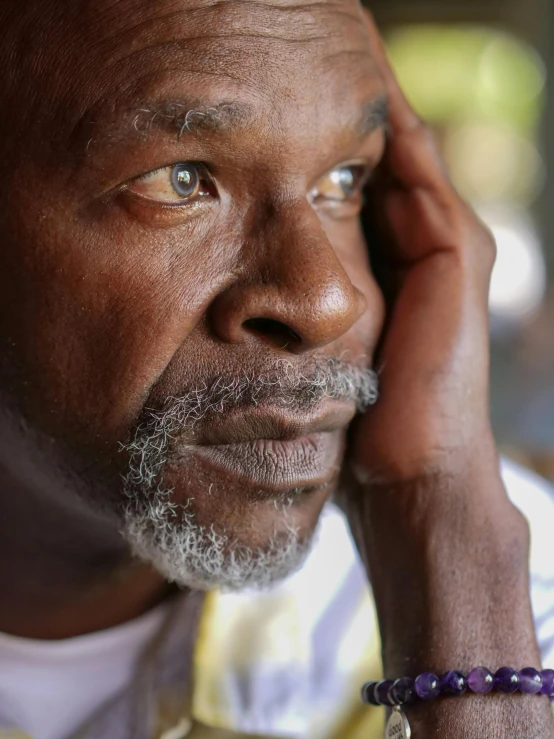 a close up of a person talking on a cell phone, deep in thought, blind brown man, grey trimmed beard, lgbtq