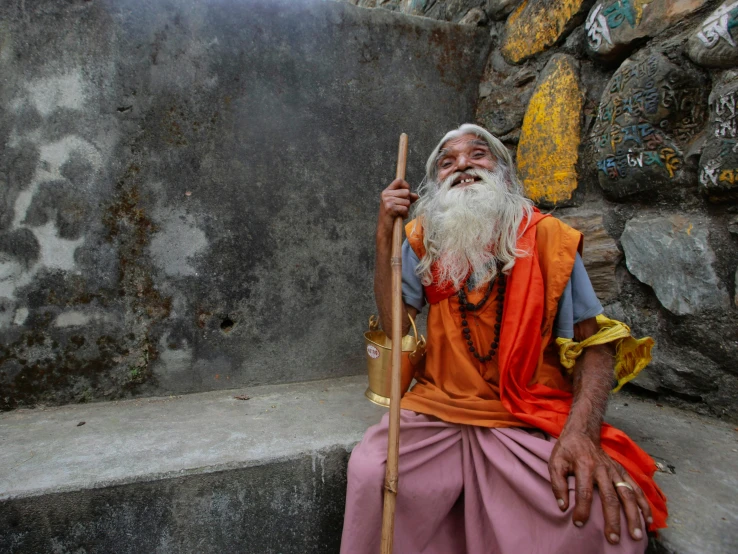 a man that is sitting down with a stick, pexels contest winner, samikshavad, mystic hermit, long and orange mustache, underground temple, thumbnail