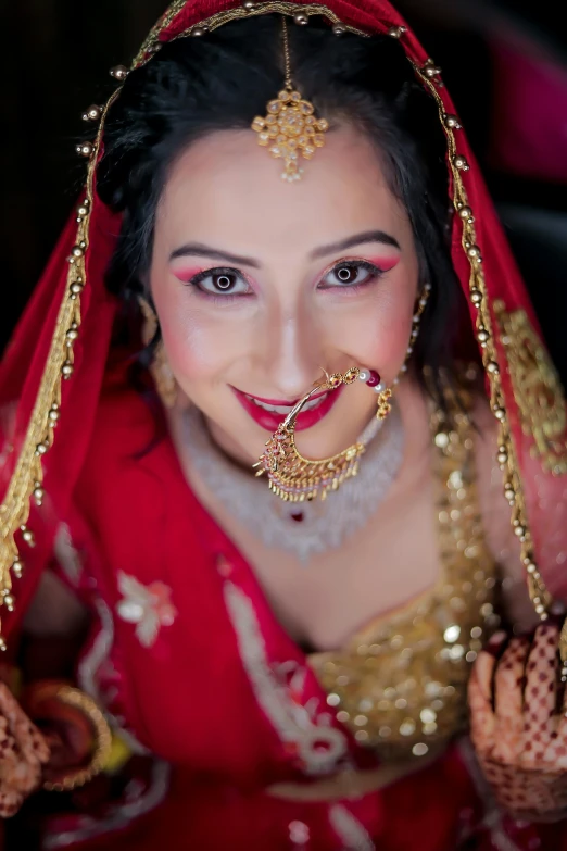 a woman in a red and gold outfit posing for a picture, a picture, by Rajesh Soni, pexels contest winner, closeup of face, square, groom, medium long shot